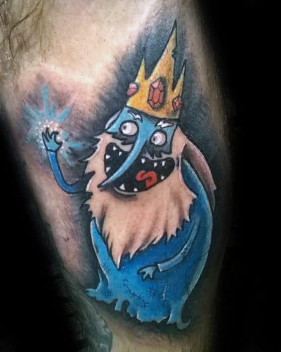 Adventure Time tattoo of the Ice King casting a spell with a mischievous grin, wearing his crown, inked on the leg.