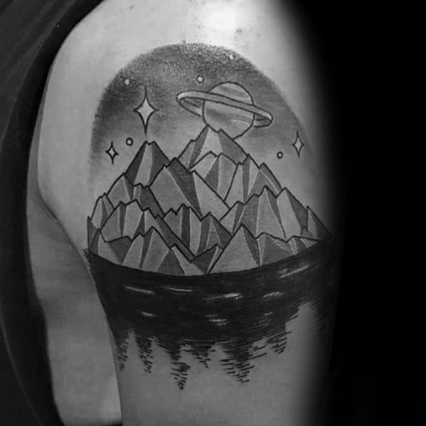 Bold blackwork tattoo of an iceberg with sharp peaks, cosmic stars, and a UFO hovering above, placed on the upper arm.