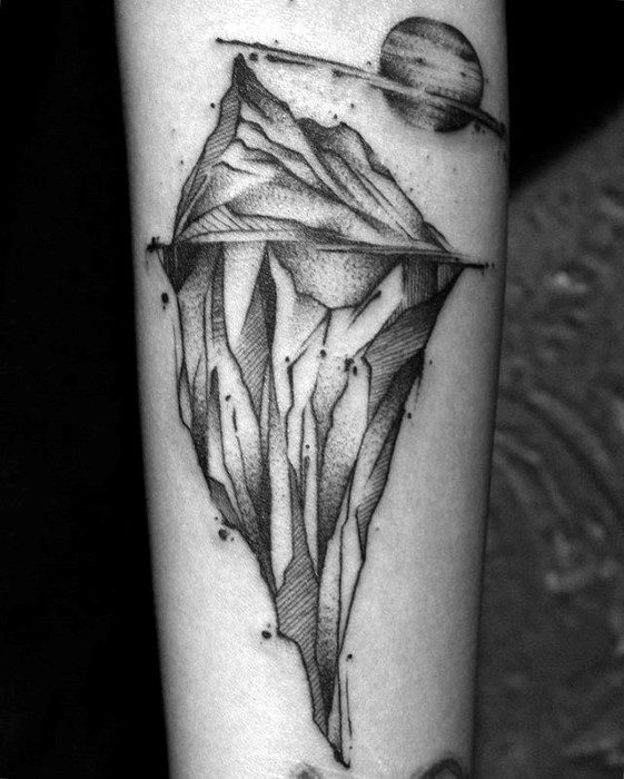 Surreal iceberg tattoo with cosmic shading and a planet with rings in the background, blending realism and abstract elements.