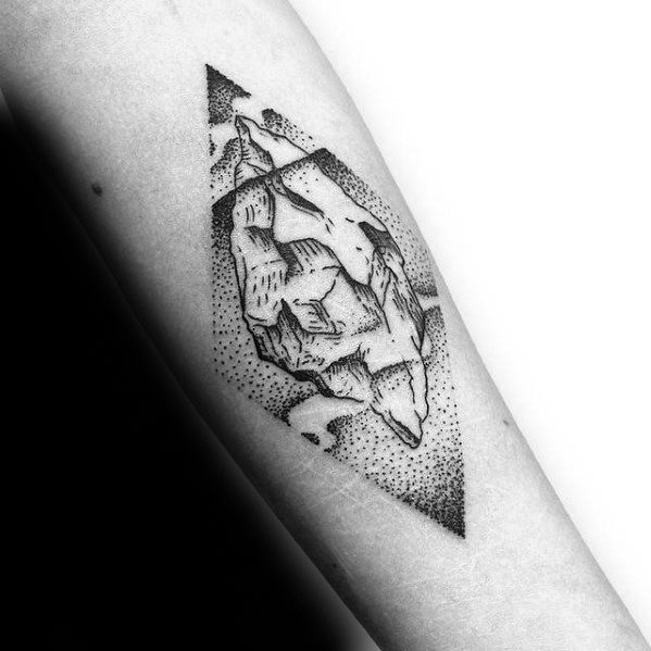 Abstract dotwork iceberg tattoo inside a diamond frame, with bold shading and fragmented shapes above and below water.