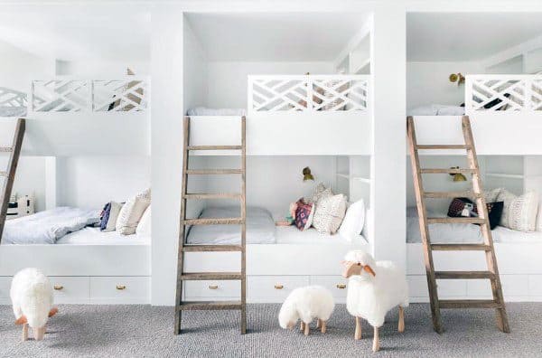 Kids’ white bunk bed room with decorative sheep, wooden ladders, cozy bedding, and soft lighting for a snug feel