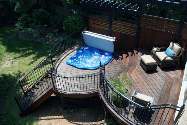 tiered wood deck black metal fence hot tub