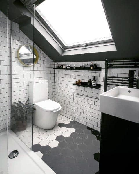 Stylish bathroom under a skylight with white subway tiles, hexagonal floor tiles, and black accents.