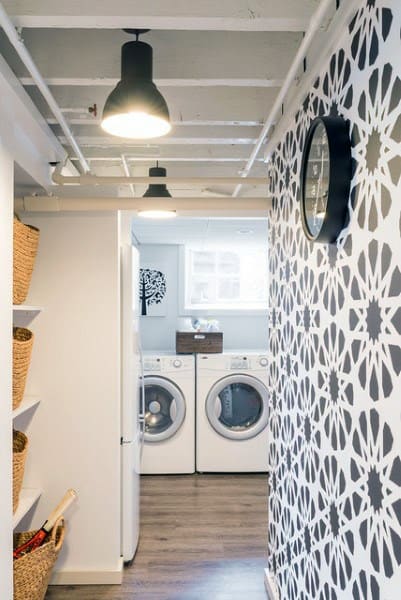 Laundry room with white exposed ceiling beams, patterned wall, and woven storage baskets.