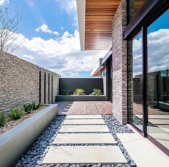 stone paver pathway backyard wood deck stone walls