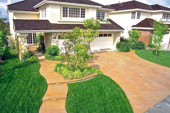 Natural stone driveway with irregular-shaped flagstones blending seamlessly with the landscaped garden.