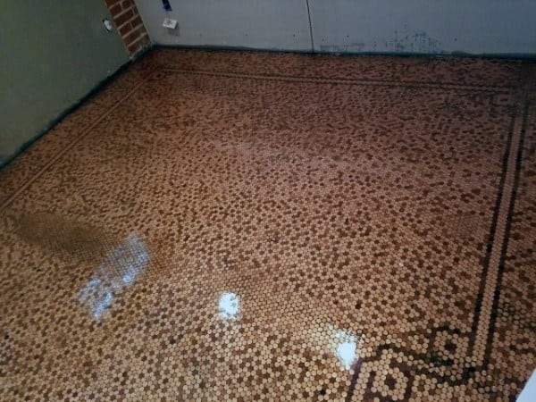 Polished penny floor featuring a classic bordered pattern design.