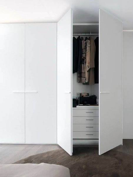 Open white closet with clothes hanging and drawers visible inside