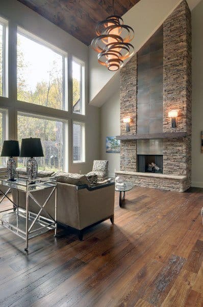 Grand stacked stone fireplace with a metal accent panel in a spacious living room with high ceilings