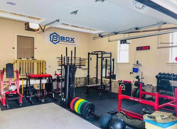 Garage gym with squat rack, weightlifting equipment, resistance bands, and neatly organized setup.