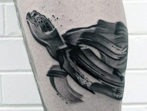 Abstract black and gray turtle tattoo on a person’s arm
