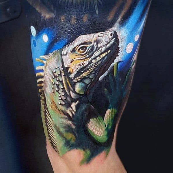 Realistic iguana tattoo with sharp detailing and vivid colors, set against a glowing blue and black abstract background.