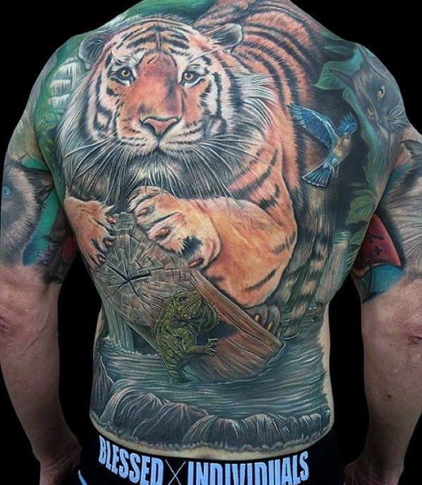 Full back tattoo of a majestic tiger stepping on a log, surrounded by a jungle scene with a frog, bird, and vibrant natural elements.