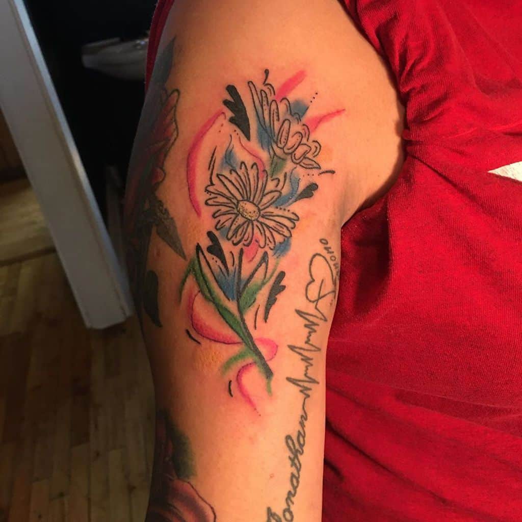 Upper arm tattoo water color illustrative line work daisy
