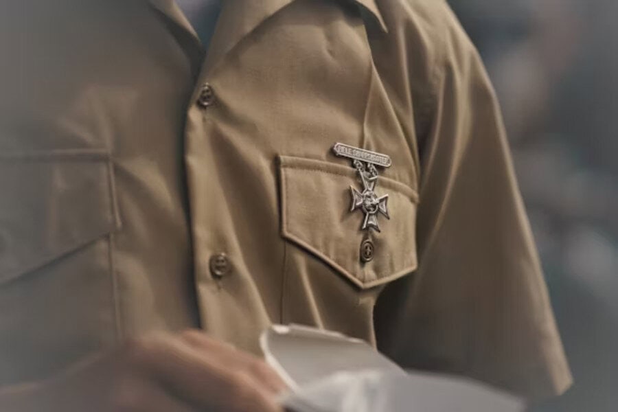 Close-up of a person in a brown uniform shirt with a sheriff's badge, conveying patriotic pride