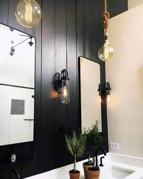 Modern bathroom with black walls, hanging light fixtures, and minimalist decor.