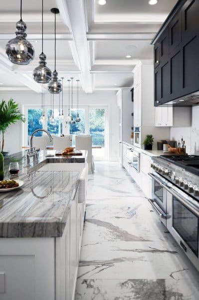 Elegant kitchen with crown molding lighting, modern marble countertops, and stylish pendant lights