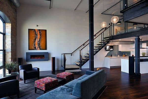 Spacious loft with modern furniture, electric fireplace, and glass staircase railing.