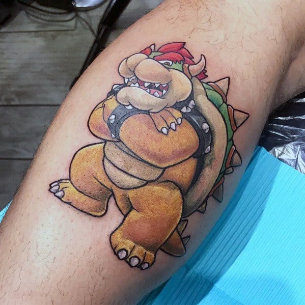 Classic Bowser tattoo on a man's leg featuring bold outlines, vibrant colors, and a confident pose, capturing his iconic look from the Mario series.