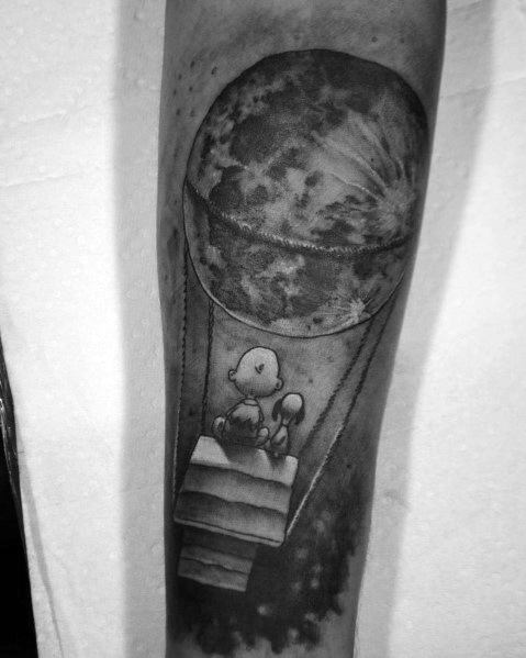 Black and white Charlie Brown and Snoopy tattoo, featuring them floating in a hot air balloon with the moon, symbolizing adventure and dreams."