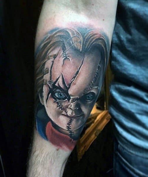 Realistic Chucky tattoo with piercing blue eyes, stitched face, and intense shading, creating a bold and haunting horror-inspired design.
