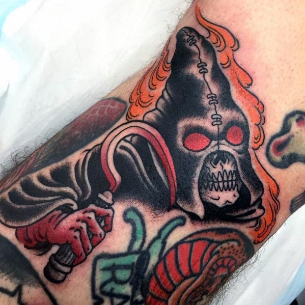 Dark executioner tattoo featuring a hooded skull with glowing red eyes, gripping a bloodied scythe, surrounded by fiery accents.