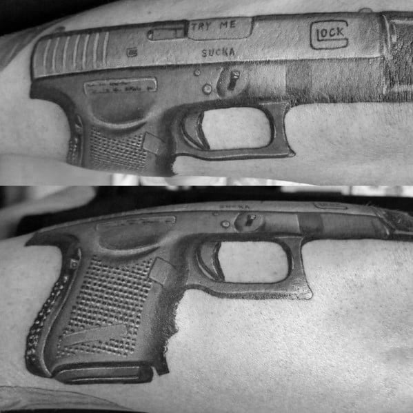 Black and grey tattoo of a Glock pistol on the forearm, featuring intricate shading and the engraved phrase "TRY ME SUCKA" for a bold statement.