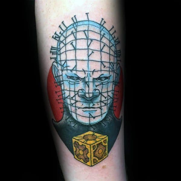 Neo-traditional *Hellraiser* tattoo of Pinhead with bold outlines, blue shading, red background, and the Lament Configuration for a striking design.