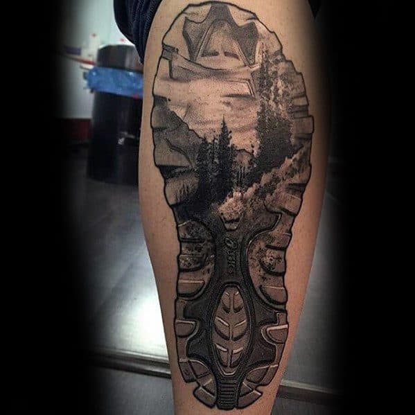 This tattoo creatively integrates a hiking boot sole with a scenic nature landscape, symbolizing adventure, exploration, and a love for the outdoors.