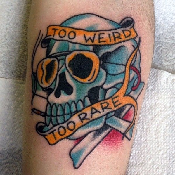 Bold Hunter S. Thompson-inspired tattoo featuring a blue skull with aviator glasses, a cigarette, and a banner reading "Too Weird, Too Rare."