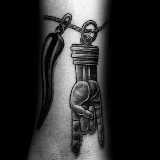 Black and grey tattoo of an Italian horn and mano cornuto pendant on a chain, symbolizing protection and warding off evil.
