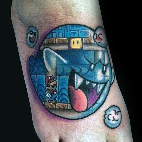 Mario ghost tattoo featuring a large Boo with a detailed Super Mario level inside, surrounded by smaller Boos, inked with vibrant colors.