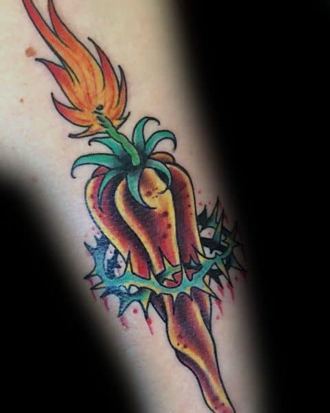 Fiery chili pepper tattoo with a flame at the stem, wrapped in a thorny vine, featuring bold colors and dynamic shading for an intense design.