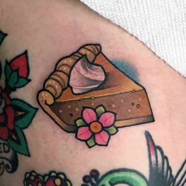 Pumpkin pie tattoo with whipped cream and a decorative flower, blending traditional tattoo style with a warm, nostalgic dessert theme