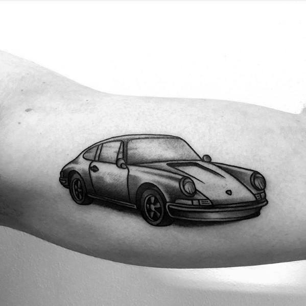 Classic Porsche tattoo in simple black shading on a man's inner arm, highlighting timeless design.