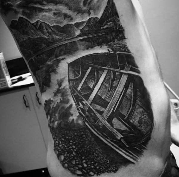Tattoo of a wooden boat on a calm lake, reflecting mountains and a cloudy sky, creating a realistic and peaceful nature scene.