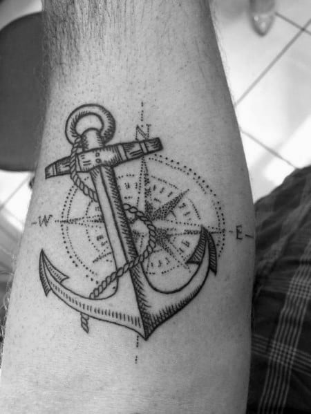 Detailed anchor and compass tattoo with fine-line dotwork, symbolizing stability and direction with a nautical-inspired design.