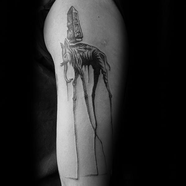 Black and grey Salvador Dali-inspired tattoo of a surreal elephant with skeletal features, long legs, and an obelisk on its back.