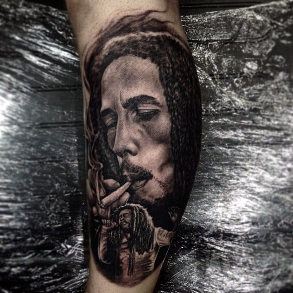Black and gray tattoo of Bob Marley smoking with a smaller figure of him performing below, blending calm and energetic moments in one design.
