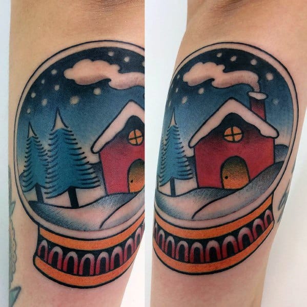 Traditional-style Christmas tattoo of a snow globe featuring a cozy red cabin, snow-covered trees, and a starry winter night for a festive holiday look.
