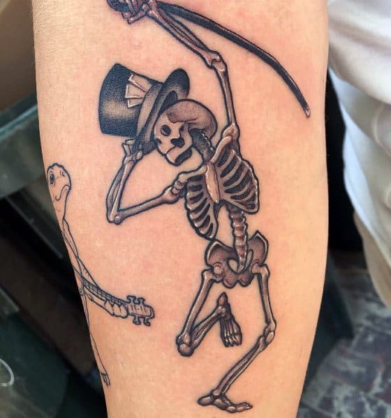 Dancing skeleton tattoo with a top hat and playful pose, featuring bold shading and fine details for a lively and stylish design.