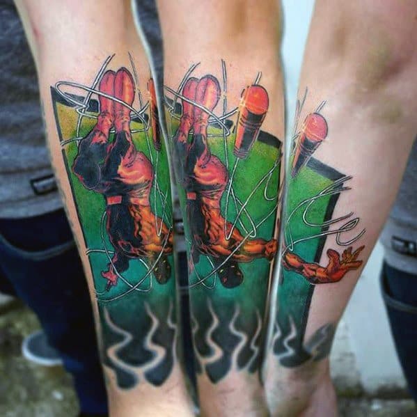 Dynamic Daredevil forearm tattoo with vivid colors, mid-air acrobatics, glowing green backdrop, and swirling baton lines.