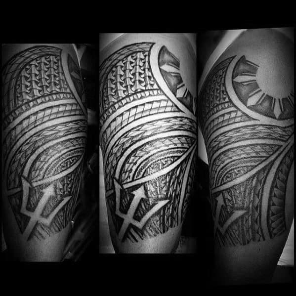 Filipino sun tattoo with tribal waves, detailed linework, and a bold trident element wrapping around the upper arm in a dense half-sleeve.