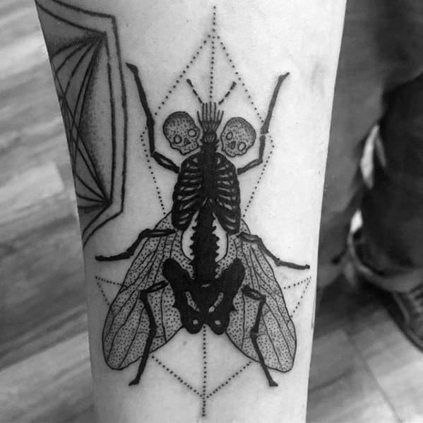 Blackwork fly tattoo with a surreal twist, featuring a double skull head, skeletal body, and geometric dotwork background.