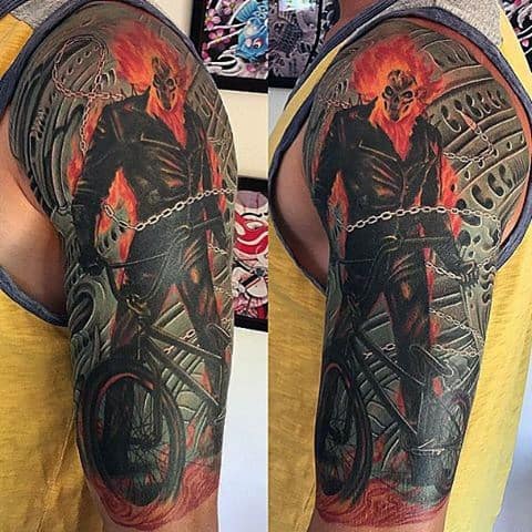 Ghost Rider upper arm tattoo showing the fiery figure standing with chains, in front of mechanical and industrial background elements.
