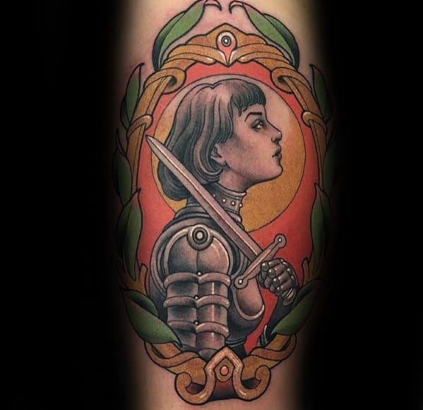 Colorful Joan of Arc tattoo in profile, framed by laurel leaves, with detailed armor and a sword against a bold orange background.