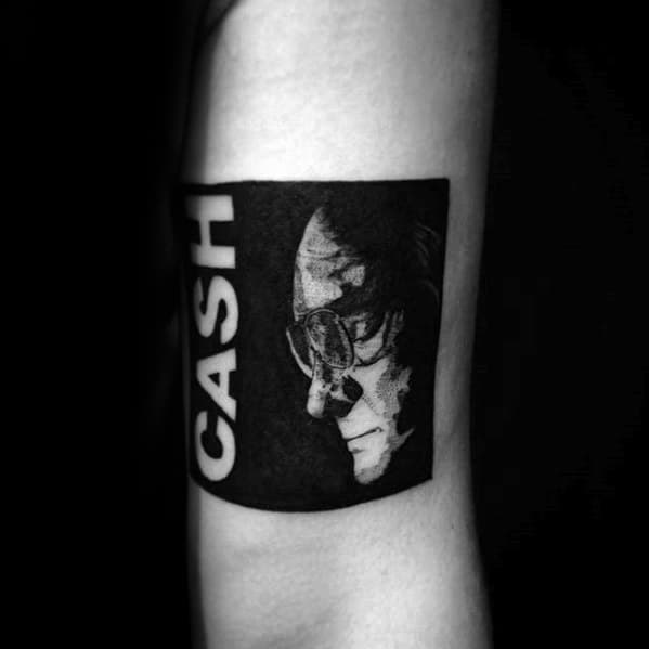 Tattoo of a monochrome portrait with "Johnny Cash" on an arm