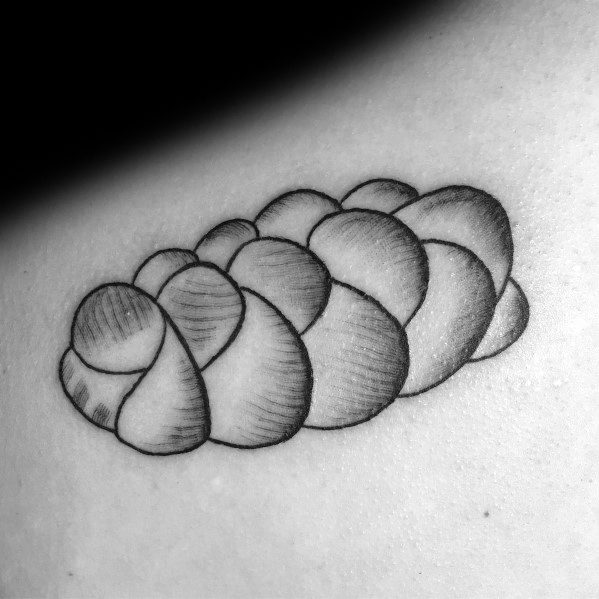 Black ink tattoo of a braided loaf of bread with fine shading, giving it a soft and textured look, perfect for a minimalist yet detailed design.