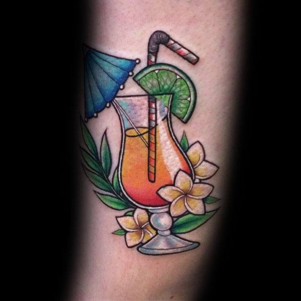 Vibrant tropical cocktail tattoo with a lime wedge, straw, umbrella, and flowers, creating a refreshing and summery beach-inspired design.