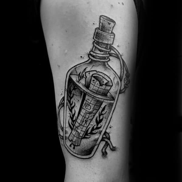 Tattoo of a message in a bottle with a cork, containing seaweed and a scroll on someone's arm